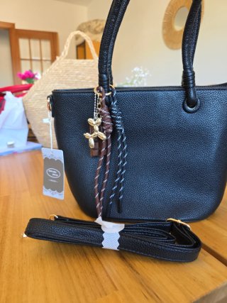 Bolso negro con llavero de perro y chocolate