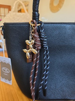 Bolso negro con llavero de perro y chocolate