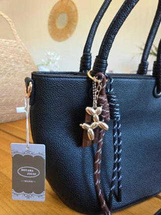 Bolso negro con llavero de perro y chocolate