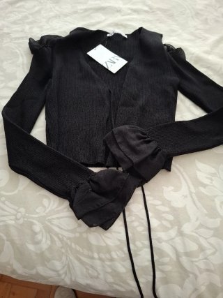 Chaqueta negra con volantes en manga y hombro