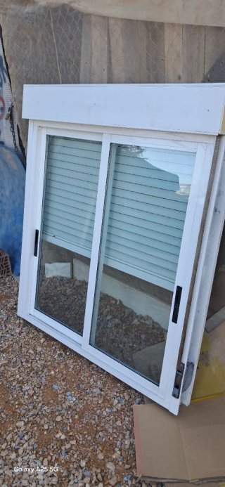 Ventana corredera blanca con persiana