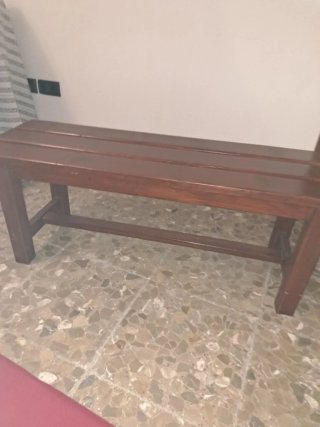 Banco de madera con cojín rojo