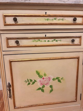 Cómoda de madera con mármol y flores