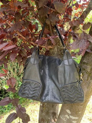 Bolso de piel negro con diseño ondulado
