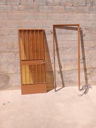 Puerta de metal marrón con marco
