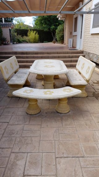 Mesa y bancos de piedra con diseño floral