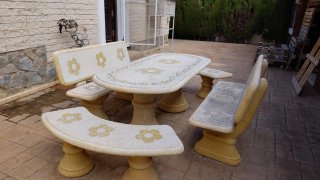 Mesa y bancos de piedra con diseño floral