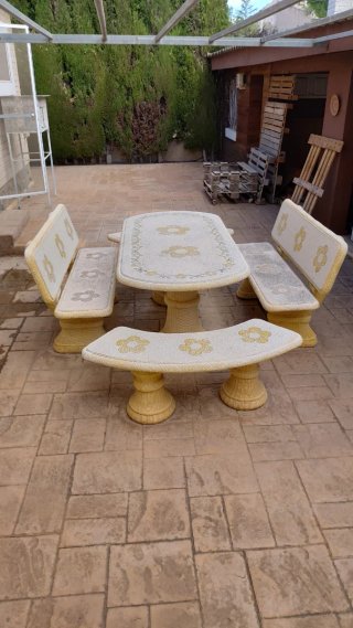 Mesa y bancos de piedra con diseño floral