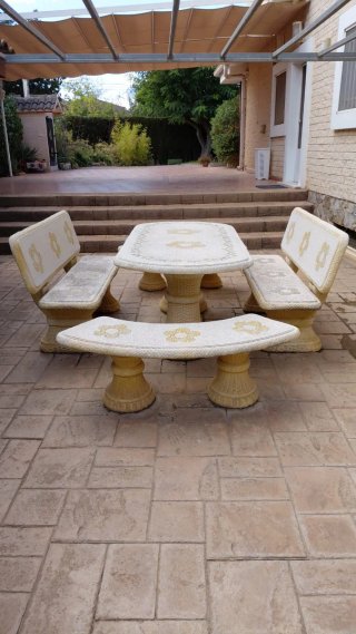 Mesa y bancos de piedra con diseño floral