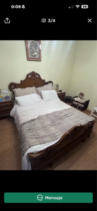 Cama de madera con cabecero tallado