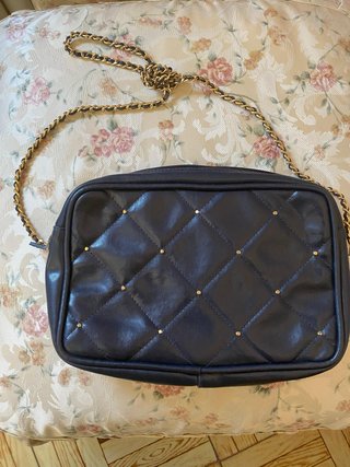 Bolso negro acolchado con cadena dorada