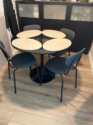 Mesa redonda negra con 4 sillas tapizadas
