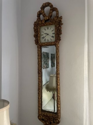 Reloj de pared dorado con espejo