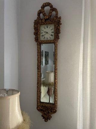Reloj de pared dorado con espejo