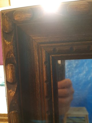 Espejo de madera con marco dorado y tallado