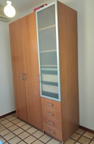 Armario de madera marrón, una puerta de cristal.