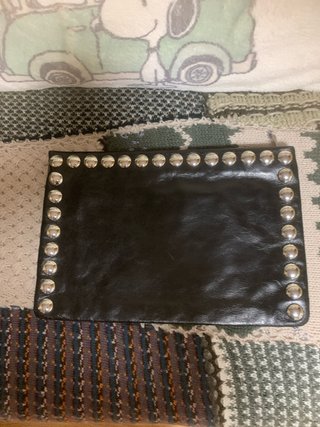 Cartera de mano negra con tachuelas