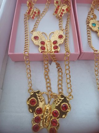 Joyería dorada con detalles rojos