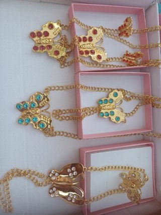 Joyería dorada con detalles rojos