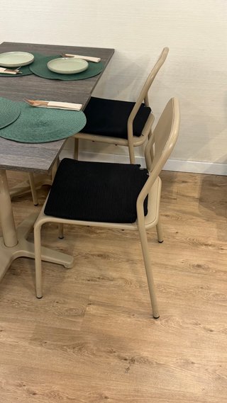 Silla de metal beige con cojín negro