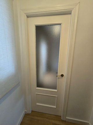 Puerta interior blanca con manilla.