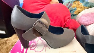 Zapato de tacón cerrado gris con hebilla.
