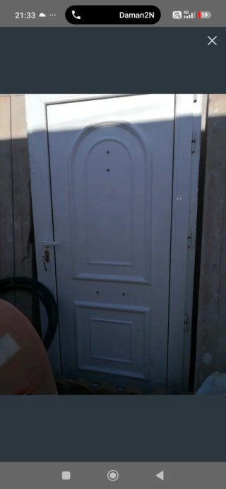 Puerta de entrada blanca con pomo dorado