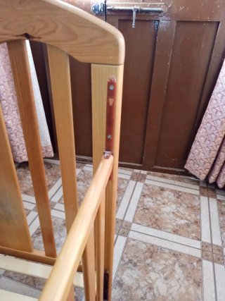 Cuna de madera color miel con ruedas