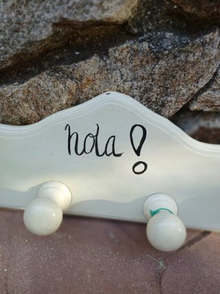 Perchero de madera con mensaje 'hola!'