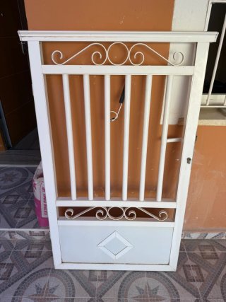 Puerta de aluminio blanca con barrotes