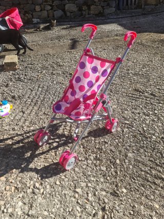 Carrito de juguete rosa con lunares se regala