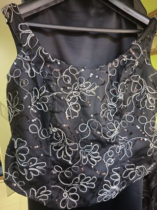 Vestido negro elegante con bordado plateado.