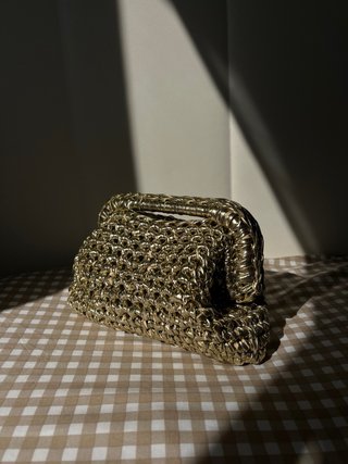 Bolso de mano dorado tejido