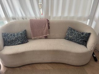 Sofá beige curvo con mesa a juego
