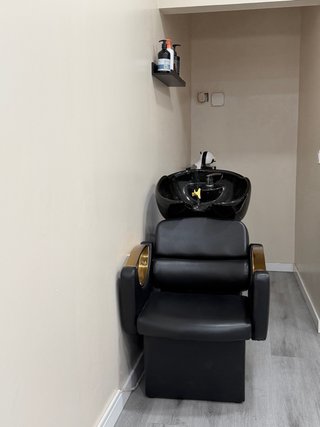 Silla de peluquería negra y dorada