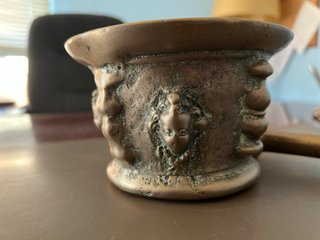 Almirez antiguo bronce 4 caras y su mano.