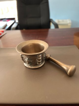 Almirez antiguo bronce 4 caras y su mano.