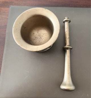 Almirez antiguo bronce 4 caras y su mano.