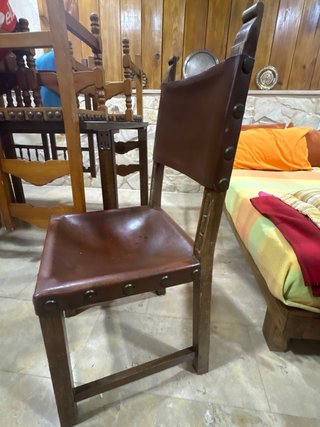 Silla antigua de cuero con revistero