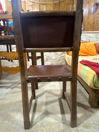 Silla antigua de cuero con revistero