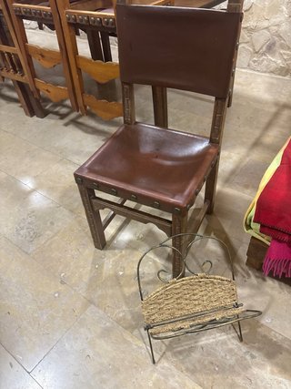 Silla antigua de cuero con revistero