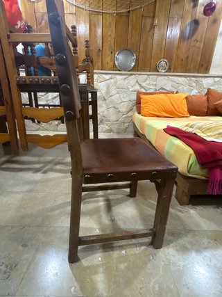 Silla antigua de cuero con revistero