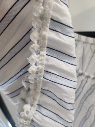Blusa de rayas azul y blanca con pompones