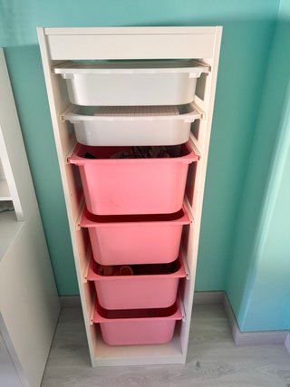 Mueble organizador con cajones rosas y blancos.
