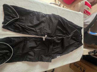 Chaqueta impermeable negra, casco y riñonera