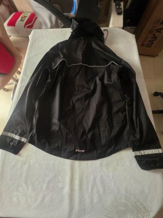 Chaqueta impermeable negra, casco y riñonera