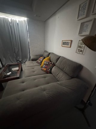 Sofá modular gris con chaiselongue y baúl