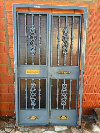 Puerta doble metal con rejas y cristal