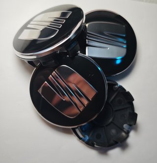 TAPABUJES SEAT 63mm NEGROS CON EMBLEMA PLATA 4 uds