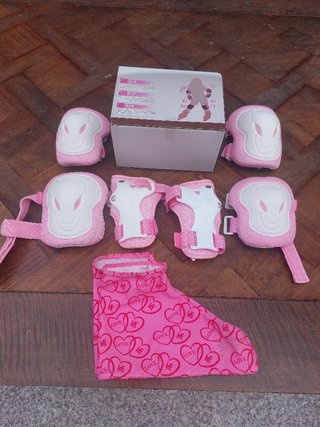 Patines de 4 ruedas rosas y equipo de protección